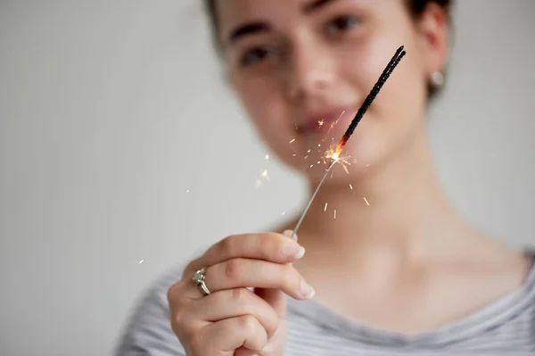 Happy young girl holding a Sparkler.The atmosphere of the festival. — Stock Photo, Image