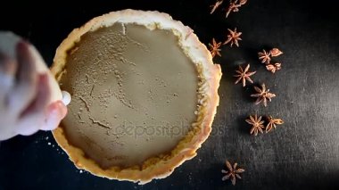 Şef ile çırpılmış krema ve krem peynir pişirme bir çanta ile pasta süsle. Yıldız anason ile dağınık tablo karanlık yüzeyinde