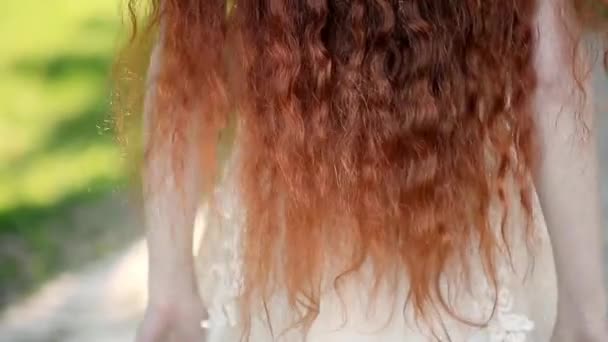 Chica con pelo rizado rojo natural.Una belleza natural. Un poco de viento enrosca tu cabello. — Vídeo de stock