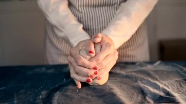 Ana toprak atar mavi tuval kumaş parçaları kneads. Clay, el yapımı modelleme