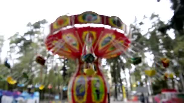 Vackra ljusa karusellen snurrar dag i parken. En helg med familjen. Oskärpa — Stockvideo