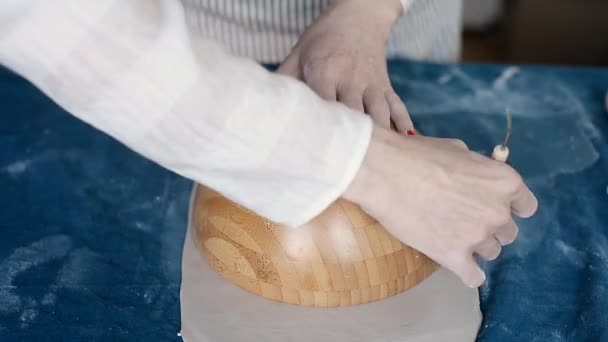 Мастер формирует керамику на голубом холсте. Творческий процесс. Придает форму вашему продукту. Рисует края в круглой чаше . — стоковое видео