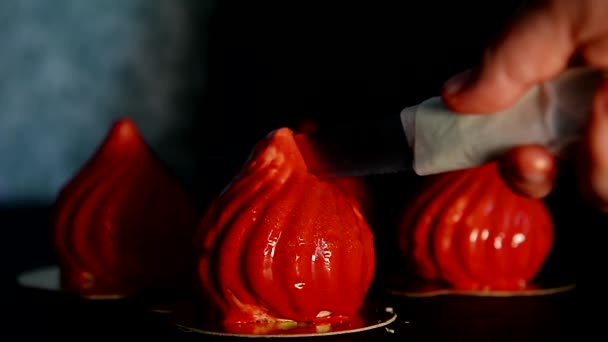 O processo de corte massovogo cupcake com recheio de damasco laranja, com um esmalte espelho vermelho. Uma obra de arte culinária — Vídeo de Stock