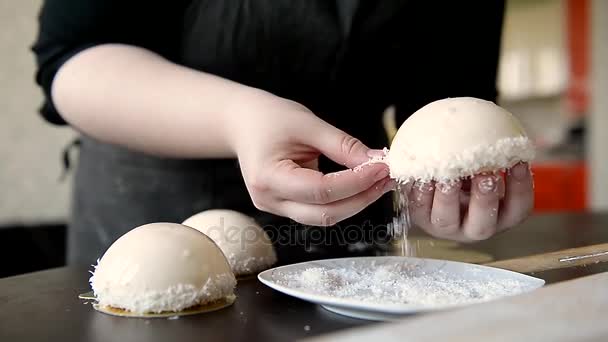 Cocinar adorna el pastel de mousse blanco con esmalte espejo y chips de coco. En el marco de la mano — Vídeo de stock