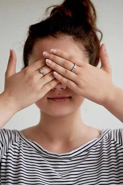 Emotions. Close-up facial portrait. See no evil.Girl on a light background closes his eyes