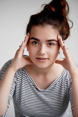 genç kız açık emin göz görünüyor. İki el bir kişinin. Çalışırken bir şey hakkında. Esmer beyaz bir arka plan üzerinde