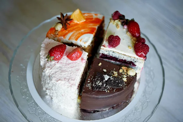 Τα διάφορα κομμάτια του κέικ περιστρέφεται ομαλά στη βάση. Υπάρχει σοκολάτα, καρότο, γιαούρτι και μούρα. — Φωτογραφία Αρχείου