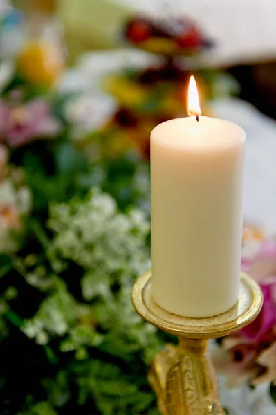A gyertya az asztalon, az ifjú arany gyertyatartót. Esküvői virágkötészet — Stock Fotó