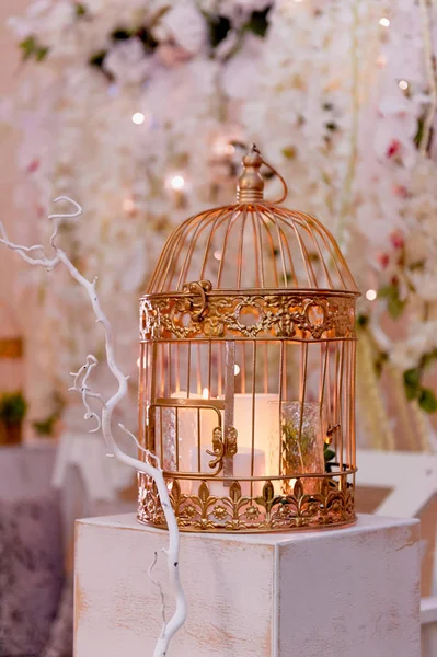 Golden cage with candles on a white wooden pedestal. Wedding photo zone — Stock Photo, Image