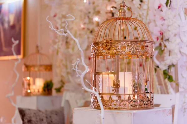 Gaiola dourada com velas em um pedestal de madeira branco. Zona de fotos do casamento — Fotografia de Stock