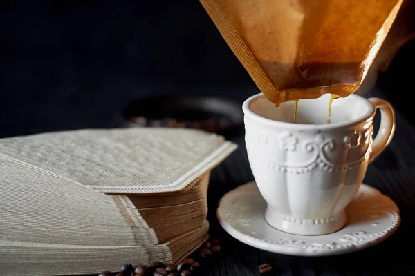 Une pile de filtres à café en papier kraft et une tasse blanche .Macro — Photo