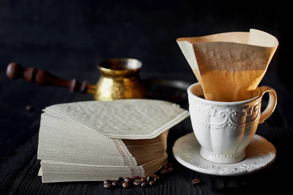 Une pile de filtres à café en papier kraft et une tasse blanche .Macro — Photo