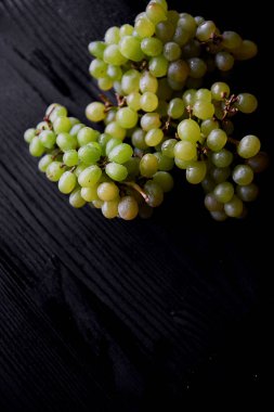 Güzel taze bir avuç üzüm koyu ahşap arka plan üzerinde. Su damlacıkları. Sağlıklı beslenme