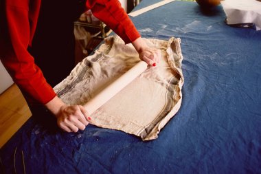 Ana Şablon şekilleri seramik mavi bir tuval üzerine. Yaratıcı süreç. Ürün şekil verir. Kil bir oklava ile yayıldı