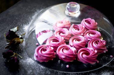 Karanlık bir yüzey üzerinde birçok mor hatmi. Zıt bir resim. Mutfak sanat eseri. Altında cam kaplama