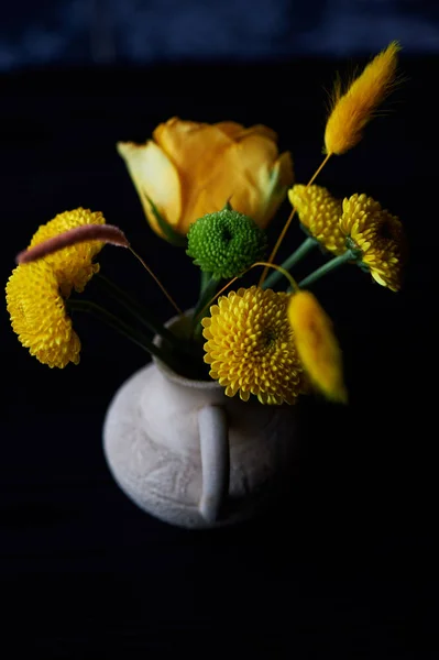 Un pequeño arreglo floral sobre fondo negro. Esquema de color verde y amarillo. Crisantemo, rosa, granos —  Fotos de Stock