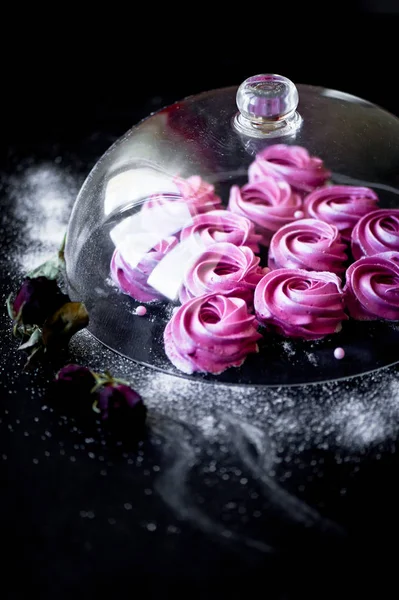 Karanlık bir yüzey üzerinde birçok mor hatmi. Zıt bir resim. Mutfak sanat eseri. Altında cam kaplama