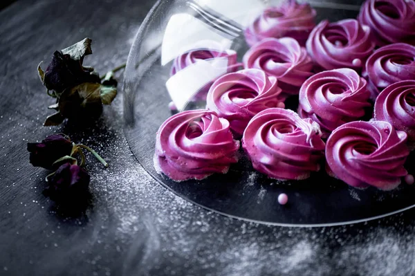 Karanlık bir yüzey üzerinde birçok mor hatmi. Zıt bir resim. Mutfak sanat eseri. Altında cam kaplama