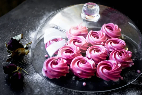 Karanlık bir yüzey üzerinde birçok mor hatmi. Zıt bir resim. Mutfak sanat eseri. Altında cam kaplama