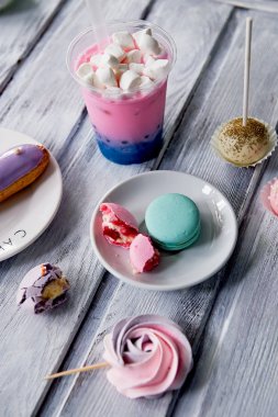 Güzel bir ahşap zemin üzerinde güzel tatlılar pastel tonları. Estetik resim. Yemek, yemek, çocuk partileri için