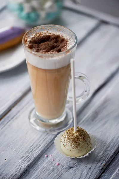 Кофе капучино с красивыми сладостями на деревянном фоне. Красивые конфеты — стоковое фото