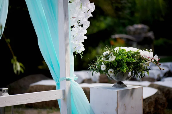 背景の湖にターコイズ色の結婚式のアーチ — ストック写真