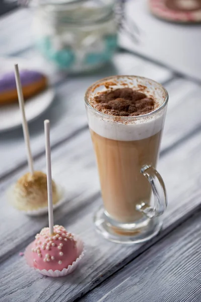 Café capuchino con hermosos dulces sobre fondo de madera. Dulces hermosos —  Fotos de Stock