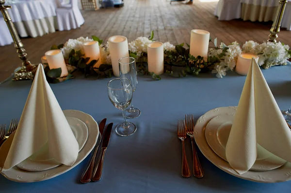 Servir table de mariage.Amidon serviettes blanches, bougie led et fleurs sur une nappe bleue. La table des jeunes mariés — Photo