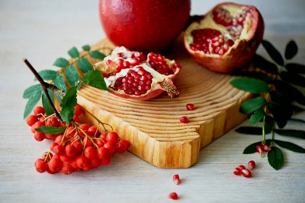 Frischer, saftiger Granatapfel auf hellem Hintergrund. auf dem hölzernen Ende davon. Als nächstes bürsten Sie die Asche. gesunde ernährung.Vegetarismus — Stockfoto