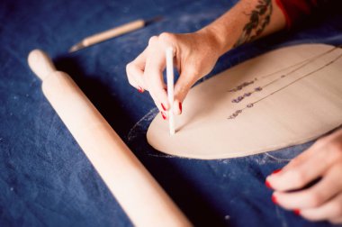 Yaratıcı atölye ustası. Kil çimlere basmak. Teknik yazdırılan desene. İş akışı