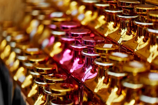 Frascos de perfume de vidrio a base de aceites.Un bazar, mercado. Macro. Oro y gamma rosa — Foto de Stock