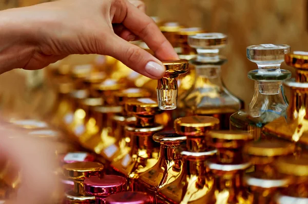Glass perfume bottles based oils.A Bazaar, market. Macro. Gold and pink gamma — Stock Photo, Image