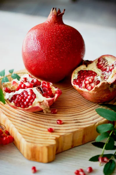 Frischer, saftiger Granatapfel auf hellem Hintergrund. auf dem hölzernen Ende davon. Als nächstes bürsten Sie die Asche. gesunde ernährung.Vegetarismus — Stockfoto