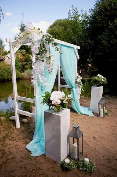 Turkuaz rengi arka plan göl kenarında düğün kemer