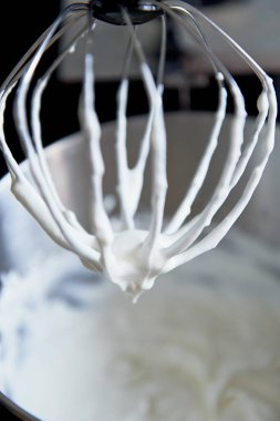 Metal fırçalamak krem şanti kalıntıları ile mikser üzerinden. pişirme