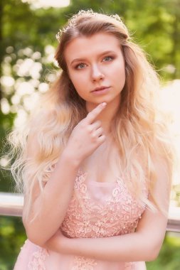 Batan güneşin dantel ile şeftali elbiseli gelinin güzel ormanda dönen siluet. İyi bir rakam ile sarışın. Mutluluk ve huzur hissi