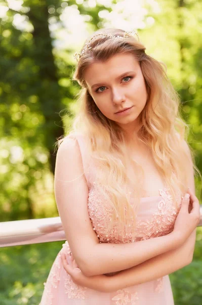 Batan güneşin dantel ile şeftali elbiseli gelinin güzel ormanda dönen siluet. İyi bir rakam ile sarışın. Mutluluk ve huzur hissi