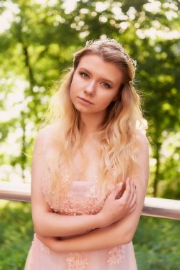 Batan güneşin dantel ile şeftali elbiseli gelinin güzel ormanda dönen siluet. İyi bir rakam ile sarışın. Mutluluk ve huzur hissi