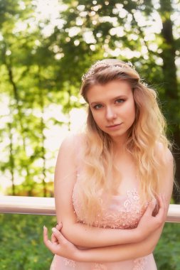 Batan güneşin dantel ile şeftali elbiseli gelinin güzel ormanda dönen siluet. İyi bir rakam ile sarışın. Mutluluk ve huzur hissi