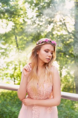 Batan güneşin dantel ile şeftali elbiseli gelinin güzel ormanda dönen siluet. İyi bir rakam ile sarışın. Mutluluk ve huzur hissi