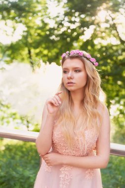 Batan güneşin dantel ile şeftali elbiseli gelinin güzel ormanda dönen siluet. İyi bir rakam ile sarışın. Mutluluk ve huzur hissi