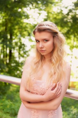 Batan güneşin dantel ile şeftali elbiseli gelinin güzel ormanda dönen siluet. İyi bir rakam ile sarışın. Mutluluk ve huzur hissi