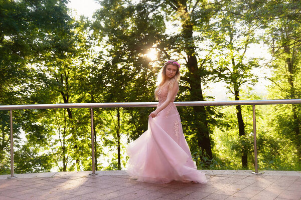Silhouette swirling in the setting sun in the beautiful woods of the bride in the peach dress with lace. Blonde with a good figure.The feeling of happiness and serenity