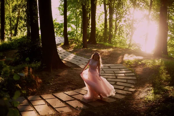 Silhouette wirbelt in der untergehenden Sonne in den schönen Wäldern der Braut im pfirsichfarbenen Kleid mit Spitze. Blondine mit einer guten Galions.das Gefühl von Glück und Gelassenheit — Stockfoto