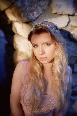 Pembe dantel elbise, saç dekorasyon, el yapımı bir güzel gelin sarışın kız portresi. Hassasiyet. Taşlar, manuel debriyaj eski duvarlar arasında yerinde duruyor. Zor ilginç günbatımı renk