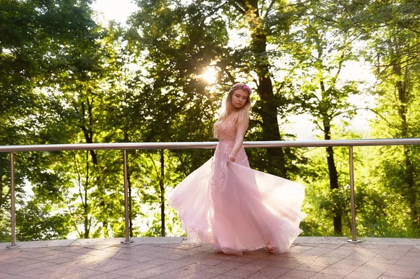 Silhouet wervelende in de ondergaande zon in de mooie bossen van de bruid in de perzik jurk met kant. Blonde met een goed figuur. Het gevoel van geluk en serenity — Stockfoto
