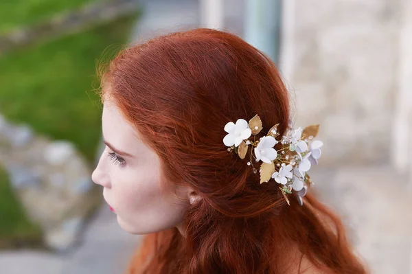 Güzel kızıl saçlı gelin geri oturur. Biraz görünür profil. El yapımı takı ile uzun kıvırcık saç. — Stok fotoğraf