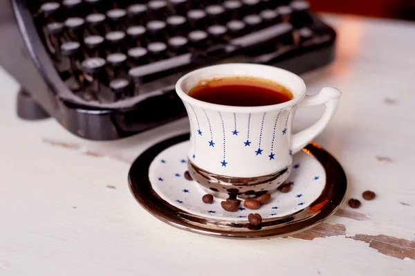 Máquina de escribir de metal vieja, cubierta de polvo y herrumbre.Taza de café sobre la mesa. El ambiente de confort y creatividad. Retro —  Fotos de Stock