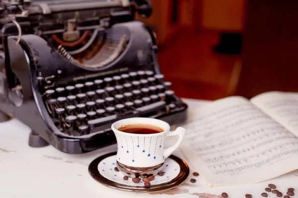 Old metal typewriter, covered in dust and rust.Cup of coffee on the table. The atmosphere of comfort and creativity. Retro — Stock Photo, Image