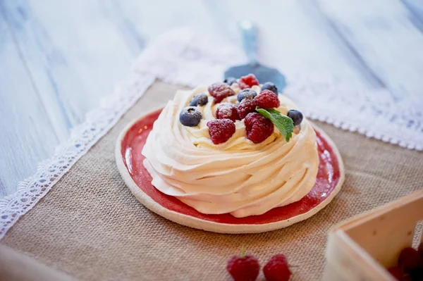 Desert Anna Pavlova cu zmeură și afine pe suprafață albă din lemn . — Fotografie, imagine de stoc